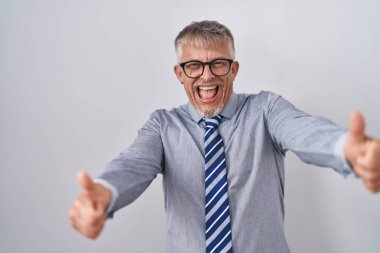 İspanyol iş adamı, gri saçlı, gözlüklü, elinde olumlu bir jest yapan, gülümseyen ve başarı için mutlu. kazanan jest. 