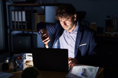 Geceleri ofiste çalışan Latin asıllı genç adam mutsuz ve kızgın görünüyor. Reddedilmiş ve olumsuz bir hareket yapıyor. kötü ifade. 