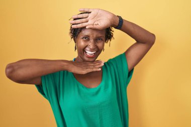 Sarı arka planda duran Afrikalı kadın gülümseyen, güler yüzlü, elleri havada bir böceği dikizleyen. Şaşırdım ve çıktım. 