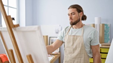 Sanat stüdyosunda resim çizen genç bir İspanyol.