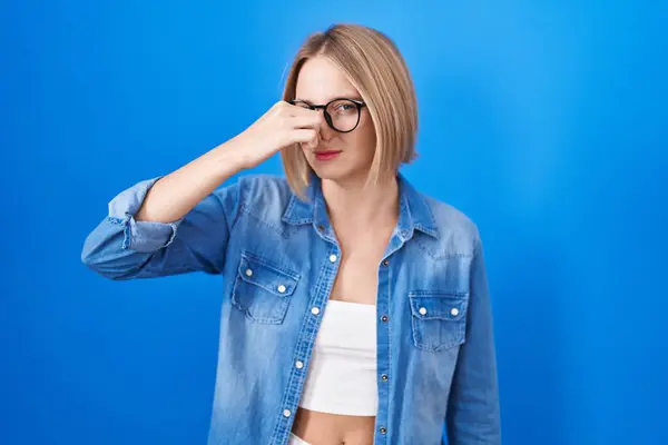 Young Caucasian Woman Standing Blue Background Smelling Something Stinky Disgusting — ストック写真