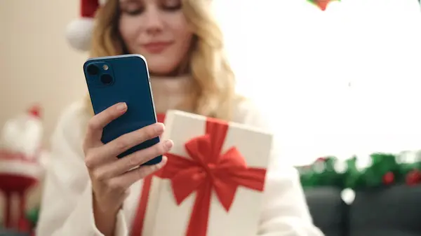 Jeune Femme Blonde Utilisant Smartphone Tenant Cadeau Noël Maison — Photo
