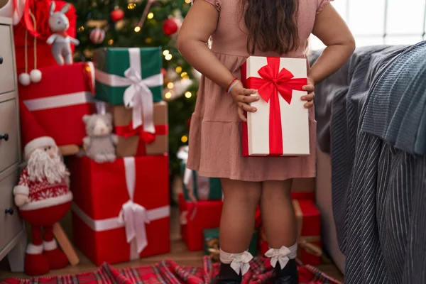 Size Hispanic Girl Holding Gift Back Standing Christmas Tree Home — Foto de Stock