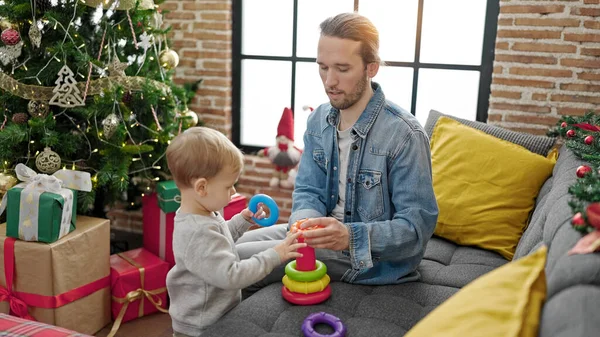 Father and son celebrating christmas playing with toys at home