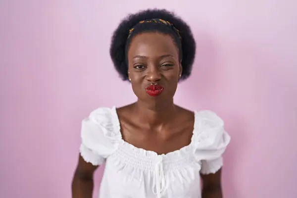 Afrikansk Kvinna Med Lockigt Hår Står Över Rosa Bakgrund Puffande — Stockfoto
