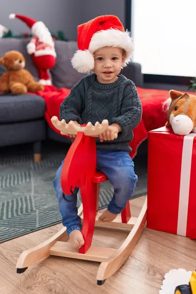 愛らしいブロンド幼児遊びますともにトナカイロッキングによってクリスマスツリーホーム — ストック写真