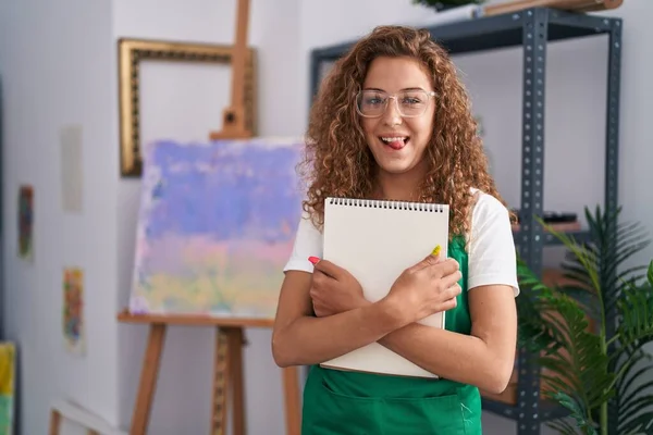 面白い表現で幸せな舌を出すアートノートを保持している若い白人女性 — ストック写真