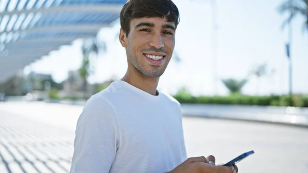 Vrolijke Jonge Spaanse Man Blij Met Behulp Van Mobiele Technologie — Stockfoto