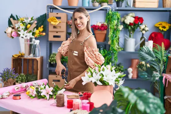 Young beautiful hispanic woman florist make bouquet of flowers at flower shop