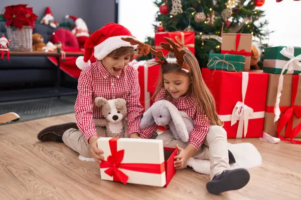 Erkek Kız Kardeş Hediyelerini Açıyor Evde Noel Ağacının Yanında Oturuyorlar — Stok fotoğraf