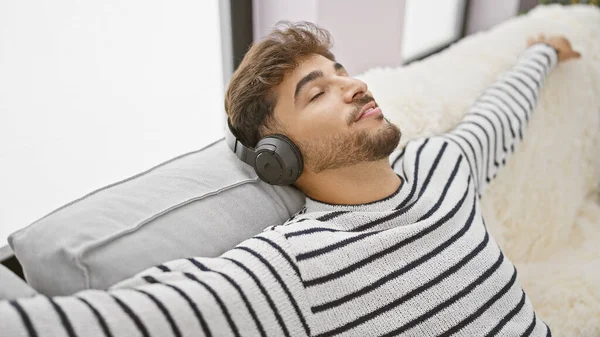 Mladý Arabský Muž Užívá Své Vlastní Zvukové Útočiště Odpočívá Pohovce — Stock fotografie