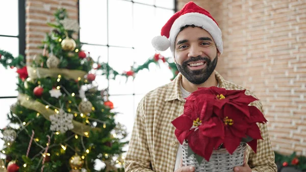 Junger Hispanischer Mann Hält Weihnachtspflanze Hause — Stockfoto