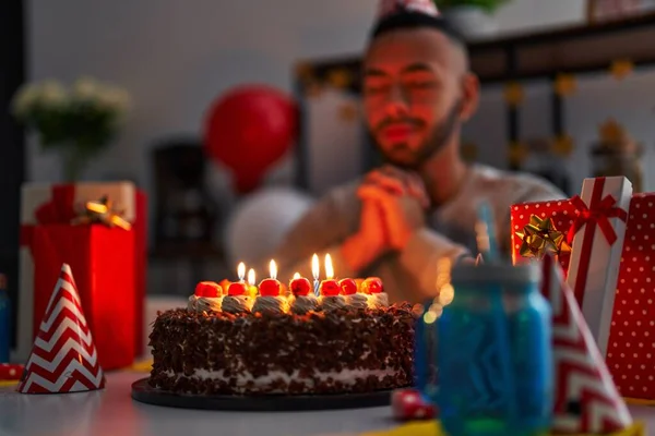 African american man celebrating birthday having wish at home