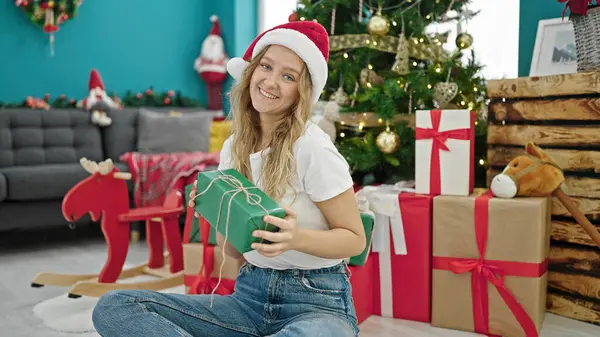 Νεαρή Ξανθιά Γυναίκα Κρατώντας Χριστουγεννιάτικο Δώρο Κάθεται Στο Πάτωμα Στο — Φωτογραφία Αρχείου