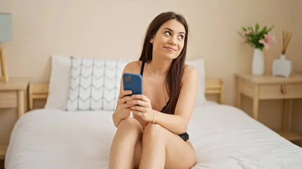 Νέα Όμορφη Ισπανόφωνη Γυναίκα Φορώντας Εσώρουχα Χρησιμοποιώντας Smartphone Στο Υπνοδωμάτιο — Φωτογραφία Αρχείου