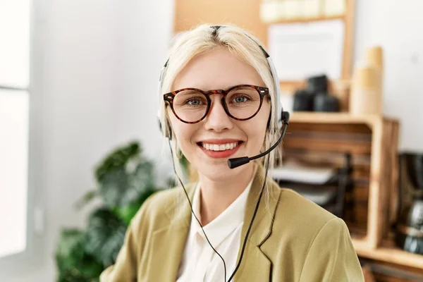Young blonde woman business worker wearing headset at office