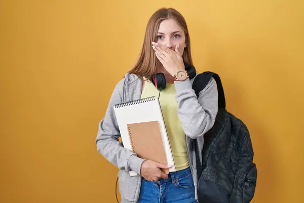 Młoda Biała Kobieta Studenckim Plecaku Trzymająca Książki Szoku Zakrywająca Usta — Zdjęcie stockowe