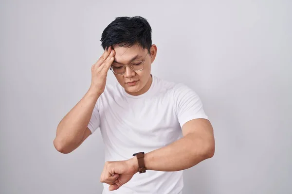Joven Asiático Hombre Pie Sobre Blanco Fondo Mirando Reloj Tiempo —  Fotos de Stock