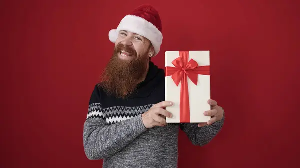 빨간색 배경에 크리스마스 모자를 선물을 — 스톡 사진