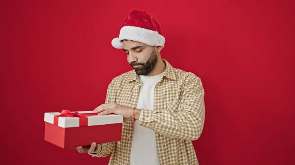 Junger Hispanischer Mann Mit Weihnachtsmütze Beim Auspacken Eines Geschenks Der — Stockfoto