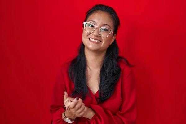 Asiatisk Ung Kvinna Står Över Röd Bakgrund Med Händerna Tillsammans — Stockfoto