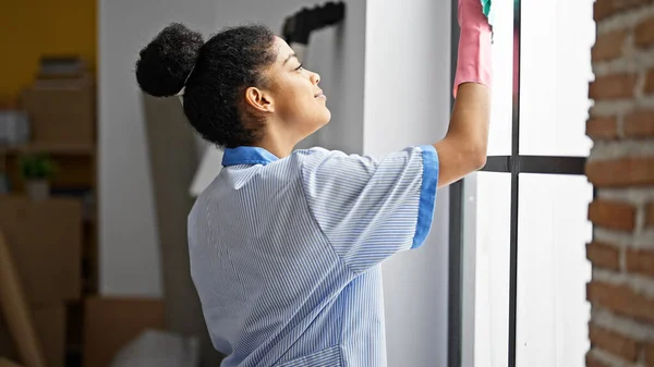 African american woman clean professional cleaning window at new home