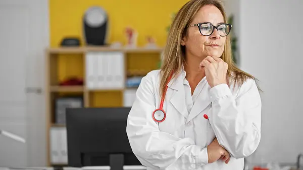 Latynoska Kobieta Średnim Wieku Lekarz Stojący Wątpliwościami Myśląc Klinice — Zdjęcie stockowe
