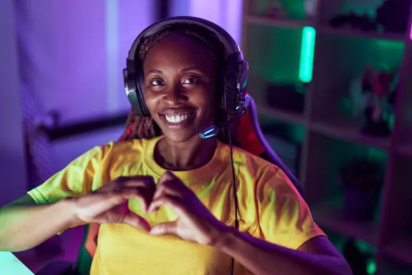 非裔美国女性流着微笑 自信地用手在游戏室做心脏的符号 — 图库照片