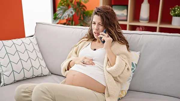 Mladá Těhotná Žena Mluví Smartphone Vážným Výrazem Doma — Stock fotografie