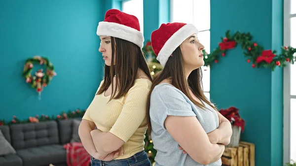 Dua Perempuan Yang Mengenakan Topi Natal Berdiri Dengan Tangan Melintas — Stok Foto