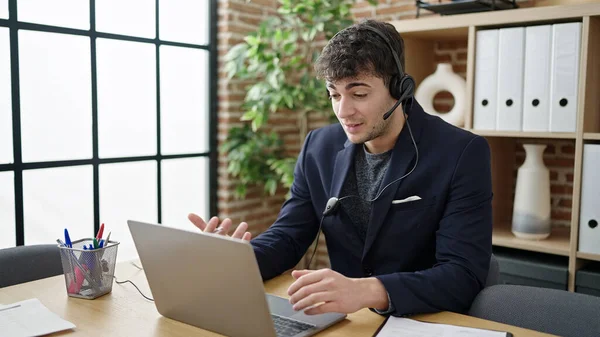 若いヒスパニック系の男性ビジネスワーカーを使用してノートパソコンを着用ヘッドセットでオフィス — ストック写真