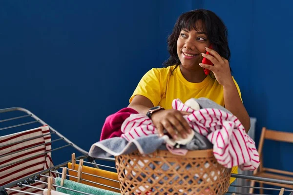 Young Beautiful Latin Woman Talking Smartphone Hanging Clothes Clothesline Laundry —  Fotos de Stock