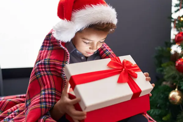 愛らしいヒスパニックの少年は 自宅でソファーに座ってクリスマスの贈り物を荷を解く — ストック写真