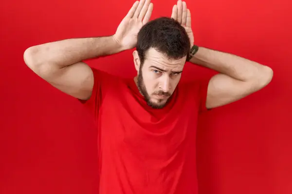 Young Hispanic Man Wearing Casual Red Shirt Doing Bunny Ears — Stock Photo, Image
