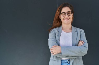 Siyahların izole edilmiş geçmişine karşı kollarını kavuşturmuş genç bir iş kadını.