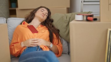 Genç, güzel İspanyol bir kadın kanepeye uzanmış, yeni evinde uyuyor.