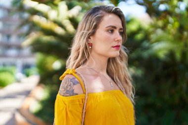 Young woman with relaxed expression standing at park