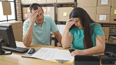 Ecommerce bürosunda endişelenen iki iş arkadaşı okuma belgesi hakkında konuşuyor