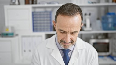 Gri saçlı, ciddi bir orta yaşlı adam, çalışkan bir bilim adamı, tıp bilimi ve teknolojinin ruhunu somutlaştıran, laboratuarda son teknoloji araştırmalarına dalmış.?