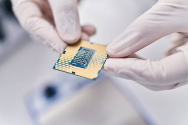Genç İspanyol bilim adamı laboratuvarda işlemci çipi tutuyor.