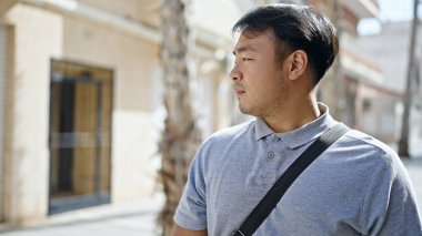  Caddede ciddi bir ifadeyle yan tarafa bakıyor.