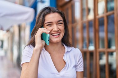 Sokakta akıllı telefon kullanan, kendine güvenen genç İspanyol kadın.