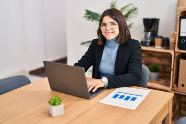 Young beautiful hispanic woman business worker using laptop working at office