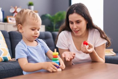 Anne ve oğlu evde oynarken kendinden emin gülümsüyor.