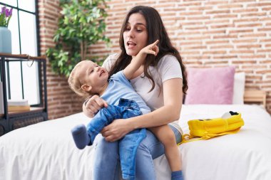 Anne ve oğlu yataklarında oturmuş, çocukları hazırlıyorlar.