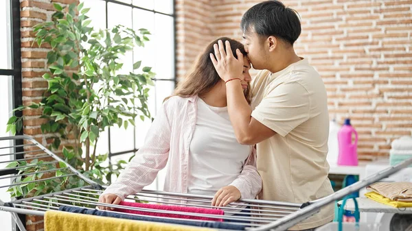 Man and woman couple stressed for chores counseling at laundry room