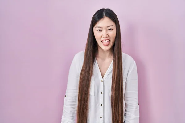 Китайская Молодая Женщина Стоящая Розовом Фоне Торчащая Языком Довольна Смешным — стоковое фото