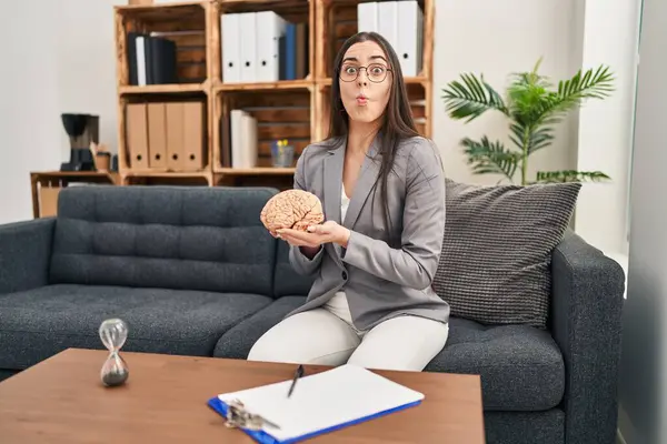Hispanic Woman Working Therapy Office Holding Brain Making Fish Face — Stock Photo, Image