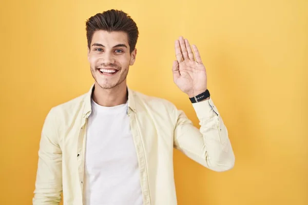 Young Hispanic Man Standing Yellow Background Waiving Saying Hello Happy — Stock Photo, Image