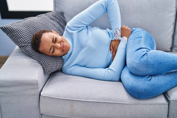 Afrikansk Amerikansk Kvinde Der Lider Menstruationssmerter Liggende Sofaen Derhjemme - Stock-foto
